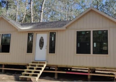 front exterior of a custom texas cabin built by ormeida with beige siding and unfinished roof